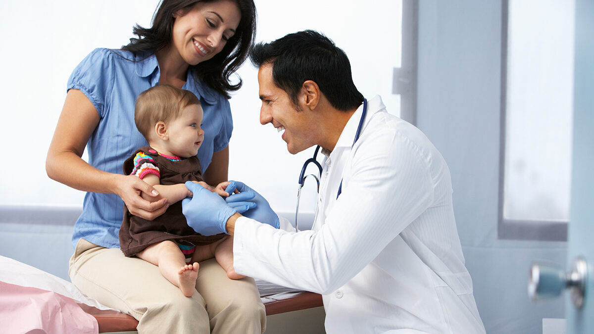 Doctor examining baby girl before giving the immunization