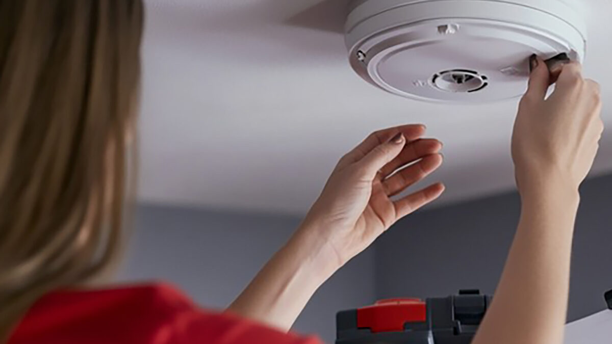 Smoke detector mounted on a ceiling representing health and safety improvements.