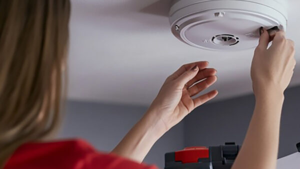 Smoke detector mounted on a ceiling representing health and safety improvements.