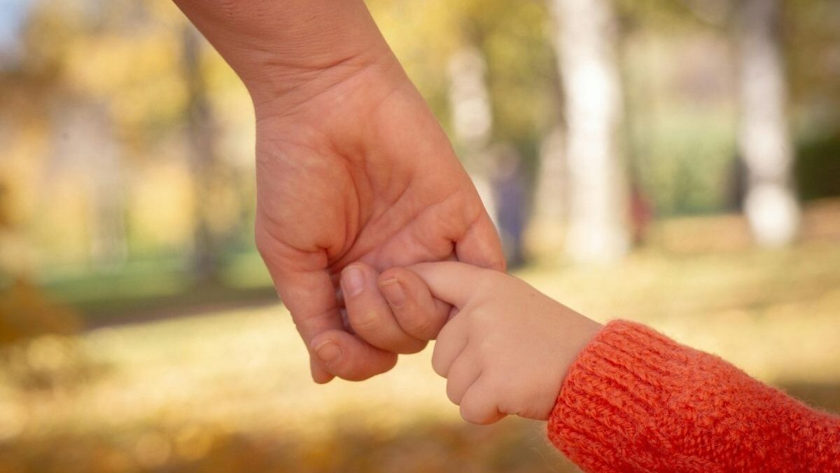 Close-up of a child and adult holding hands, illustrating the trust and care shared in every My Child Care Plan provider profile.”